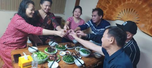a group of people sitting around a table with food at Homestay duy mạnh gần suối nước khoáng nóng trạm tấu in Cham Ta Lao