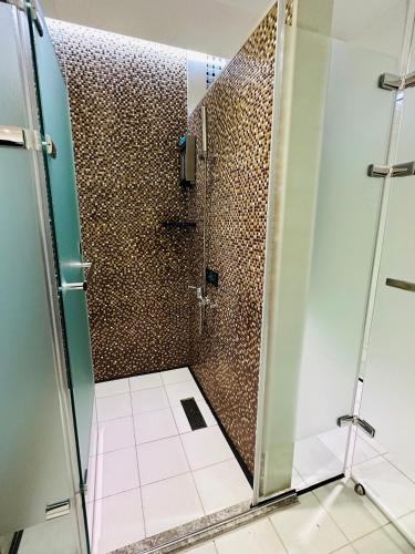 a shower with a glass door in a bathroom at TY Motel in Dayuan