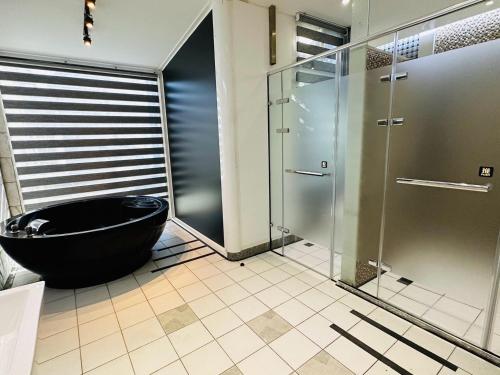 a bathroom with a black tub and a shower at TY Motel in Dayuan