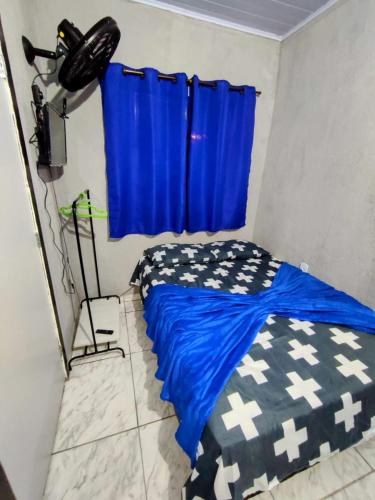 - une chambre avec un lit et un rideau bleu dans l'établissement Solar palmer 6, à Cabo Frio