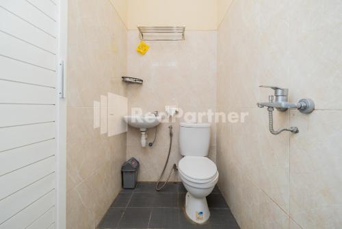 a bathroom with a toilet and a sink at Swun Stay Inn At Sawahan Mitra RedDoorz in Malang