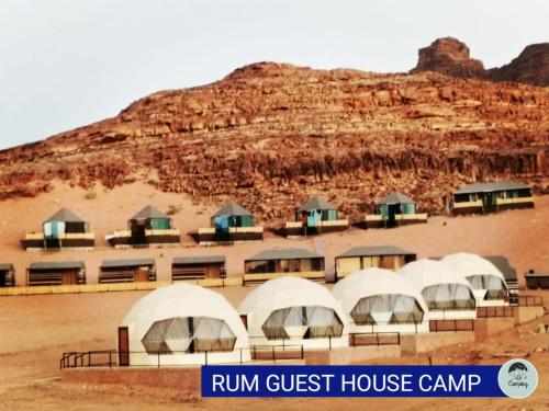 a building with domes in front of a mountain at rum guest house in Wadi Rum