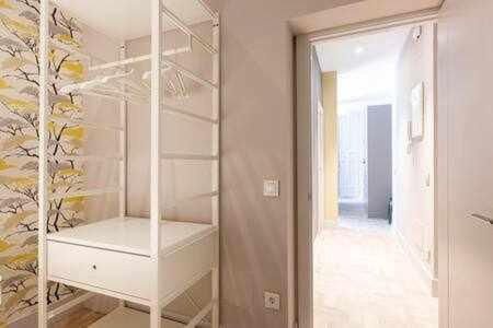 um quarto com um armário branco com uma porta de vidro em Precioso APT en la Plaza de la PAJA LATINA em Madri