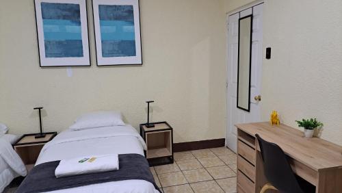 a bedroom with two beds and a desk with two lamps at Casa Colibrí Apartamento 2A in Guatemala