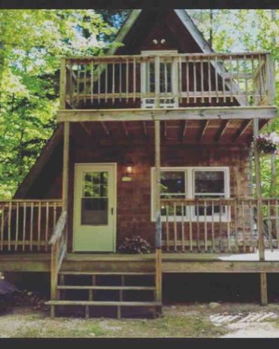 a log cabin with a large deck and a porch at All Points' End in Naples