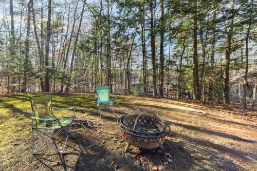two chairs and a fire pit in the woods at All Points' End in Naples