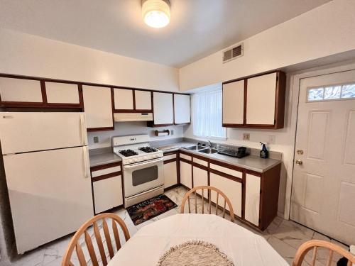 a kitchen with a white refrigerator and a table at Cheerful Two Bedroom Central Location Downtown in Baltimore