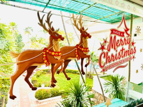 a merry christmas sign with two reindeer decorations at Century Riverside Hue in Hue