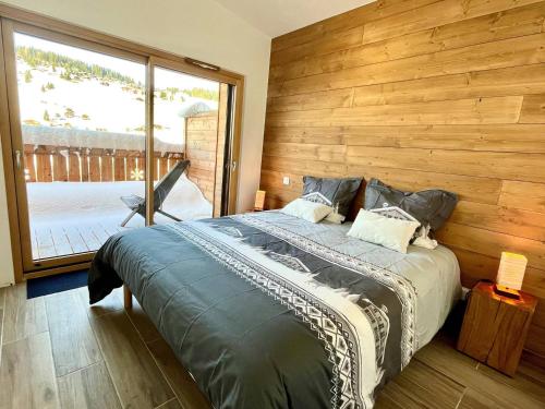 ein Schlafzimmer mit einem großen Bett und einer Holzwand in der Unterkunft Appartement Notre-Dame-de-Bellecombe, 3 pièces, 4 personnes - FR-1-505-203 in Notre-Dame-de-Bellecombe
