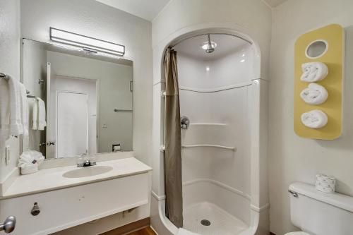 a white bathroom with a shower and a sink at Motel 6 Ogden, UT- Downtown in Ogden