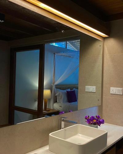 a bathroom with a sink in front of a mirror at Maison Samara in Hikkaduwa