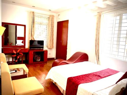 a bedroom with a bed and a chair and a television at Vera Hotel Hà Nội in Hanoi