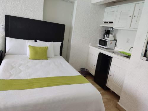 ein Schlafzimmer mit einem großen Bett und einer Mikrowelle in der Unterkunft “Magic Sunrise at Cancun” in Cancún