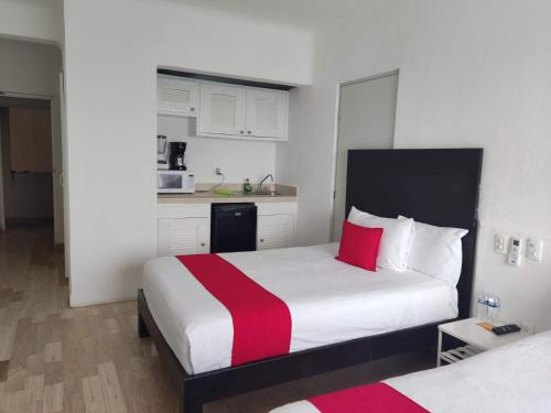 sypialnia z łóżkiem z czerwonym i białym kocem w obiekcie “Magic Sunrise at Cancun” w mieście Cancún