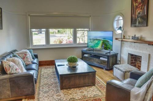 a living room with couches and a tv and a fireplace at Stylish Family Friendly Escape in Ballarat
