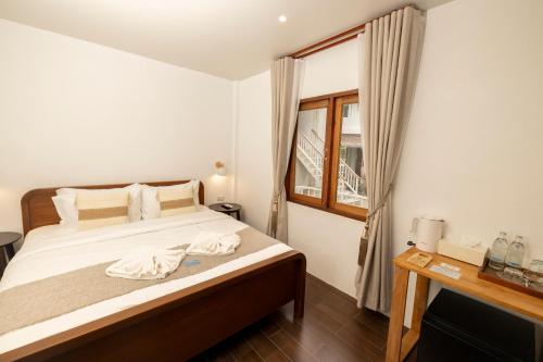a bedroom with a bed with white sheets and a window at The AVA Resort Koh Tao in Koh Tao