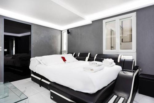 ein Schlafzimmer mit einem großen weißen Bett und Stühlen in der Unterkunft Modern Loft in Paris Center! in Paris