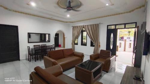 a living room with a couch and chairs and a table at CHILL GUEST HOUSE CENANG in Pantai Cenang