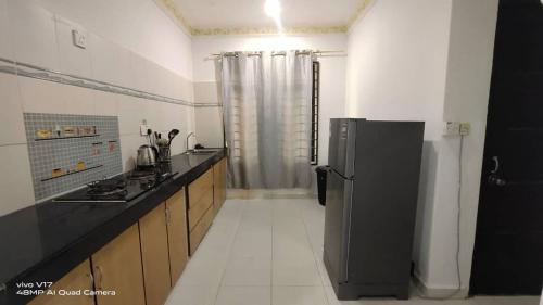 a kitchen with a black refrigerator in a room at CHILL GUEST HOUSE CENANG in Pantai Cenang