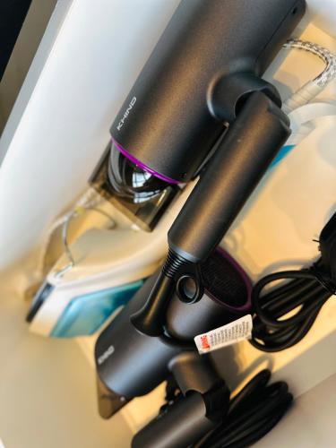 a desk with a hair dryer on a desk at New Comfy Urban Suite Homestay at Georgetown for family by Urban Staycations LOD in Jelutong