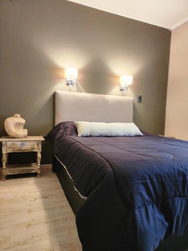 a bedroom with a bed with two lights on the wall at Casa Boutique LUNA LUCIA in Monte Hermoso