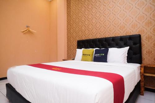 a bedroom with a large bed in a room at Urbanview Hotel L'Tefa Pemalang in Padurekso