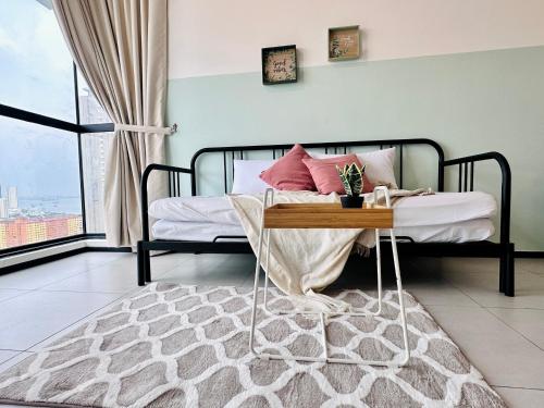 a bedroom with a bed with a table at New Comfy Urban Suite Homestay at Georgetown for family by Urban Staycations LOD in Jelutong