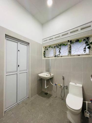 a bathroom with a toilet and a sink at GreenPine Kota Tinggi Homestay in Kota Tinggi
