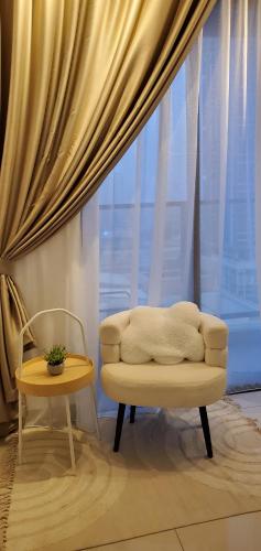 a room with a chair and a window at Trion Dual Key Option - Tallest Residential Tower in Kuala Lumpur