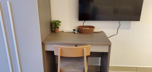 a desk with a chair and a television on a wall at Trion Dual Key Option - Tallest Residential Tower in Kuala Lumpur