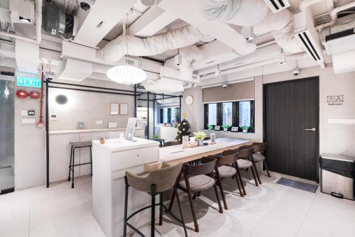 an office with a long bar with stools at Jyu Capsule Hotel in Singapore