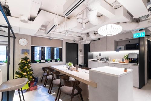 a kitchen with a christmas tree and a long table at Jyu Capsule Hotel in Singapore