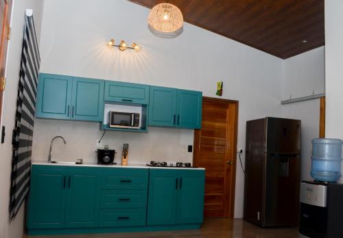 eine Küche mit blauen Schränken und einem Kühlschrank in der Unterkunft VILLA LAS LAPAS in San Buenaventura