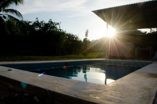 ein Schwimmbad mit Sonne im Hintergrund in der Unterkunft VILLA LAS LAPAS in San Buenaventura