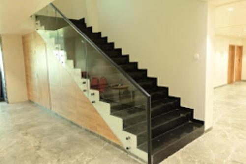 a staircase in a house with glass railing at Hotel Neptune Palace , Anand in Anand