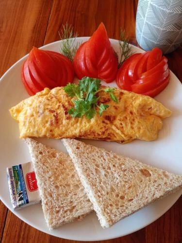 a plate of food with omelet and tomatoes on it at AJ Paradise Resort Aonang Krabi in Ao Nang Beach