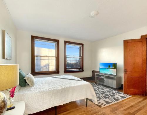 a bedroom with a bed and a flat screen tv at 1 Bed Apt on Grand - Walk to 3 Breweries! in Des Moines