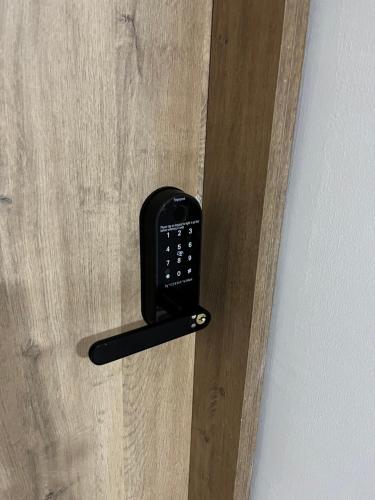 a black remote control hanging on a wooden door at Hospedajes Silk Road in Tuluá