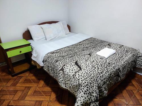a bedroom with a black and white bed with a night stand at Sierra Verde - Muy Céntrico Hs in Huancayo