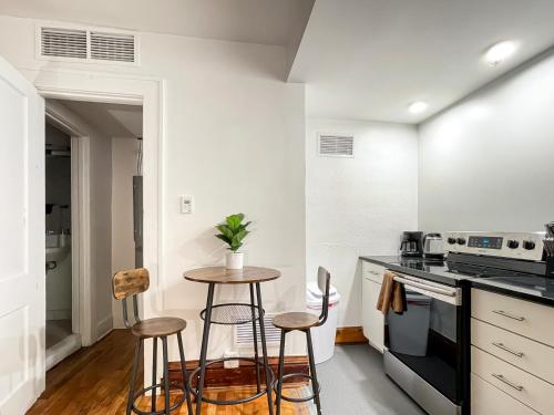 a kitchen with a table and two stools at Quiet Studio on Grand - Downtown DSM! in Des Moines