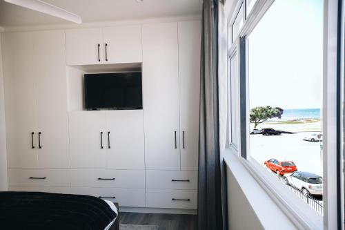 um quarto com uma janela com vista para a praia em Beachfront Luxury Family Escape em Cidade do Cabo