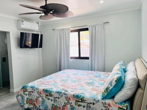 - une chambre avec un lit et un ventilateur de plafond dans l'établissement Mirah's Villa & Apartments, 