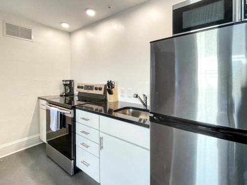 a kitchen with a stainless steel refrigerator and a sink at 1 Bed Apt on Grand - Walk to 3 Breweries! in Des Moines