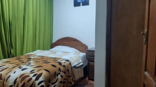 a bedroom with a bed and green curtains at Sierra Verde - Muy Céntrico Hs in Huancayo