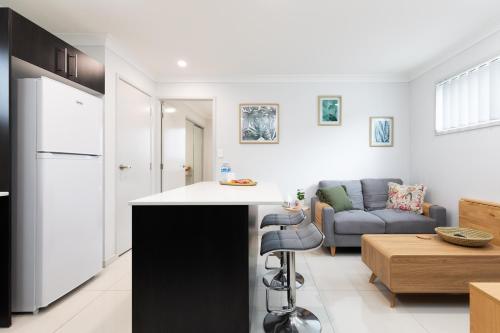 a kitchen and living room with a counter and a couch at New Listing! Air-Con and Well Presented! in Brisbane