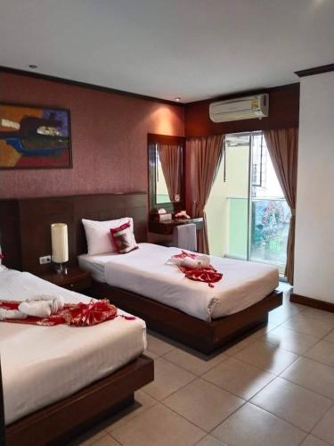 a hotel room with two beds with red roses on them at LUCKY WAYS PATONG HOTEL in Patong Beach