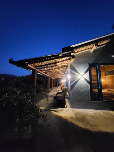 a building with a light on the side of it at Zenoaks Homestay in Almora