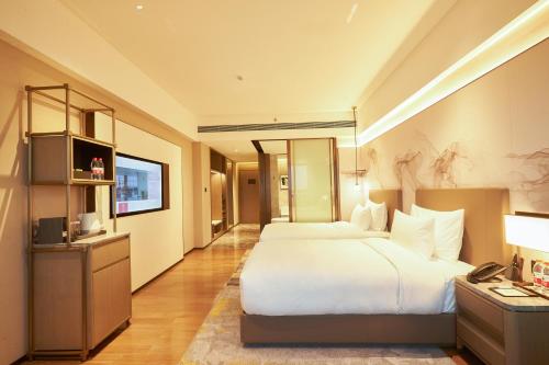 Ein Bett oder Betten in einem Zimmer der Unterkunft Guangzhou Pazhou LN DongFang Hotel-Free shuttle between hotel and Exhibition Center during Canton Fair & Exhibitor Registration Counter