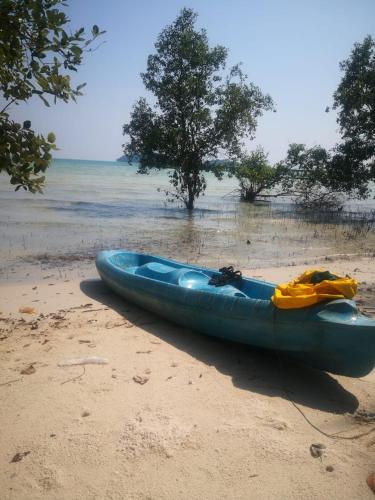 a blue kayak sitting on the sand on a beach at Friend of Nature Bungalow in Koh Rong Island