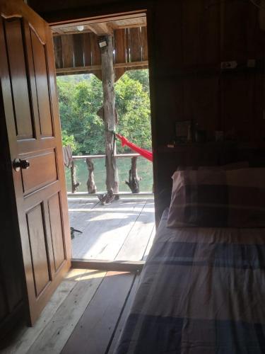 a bedroom with a door open to a porch with a bed at Friend of Nature Bungalow in Koh Rong Island